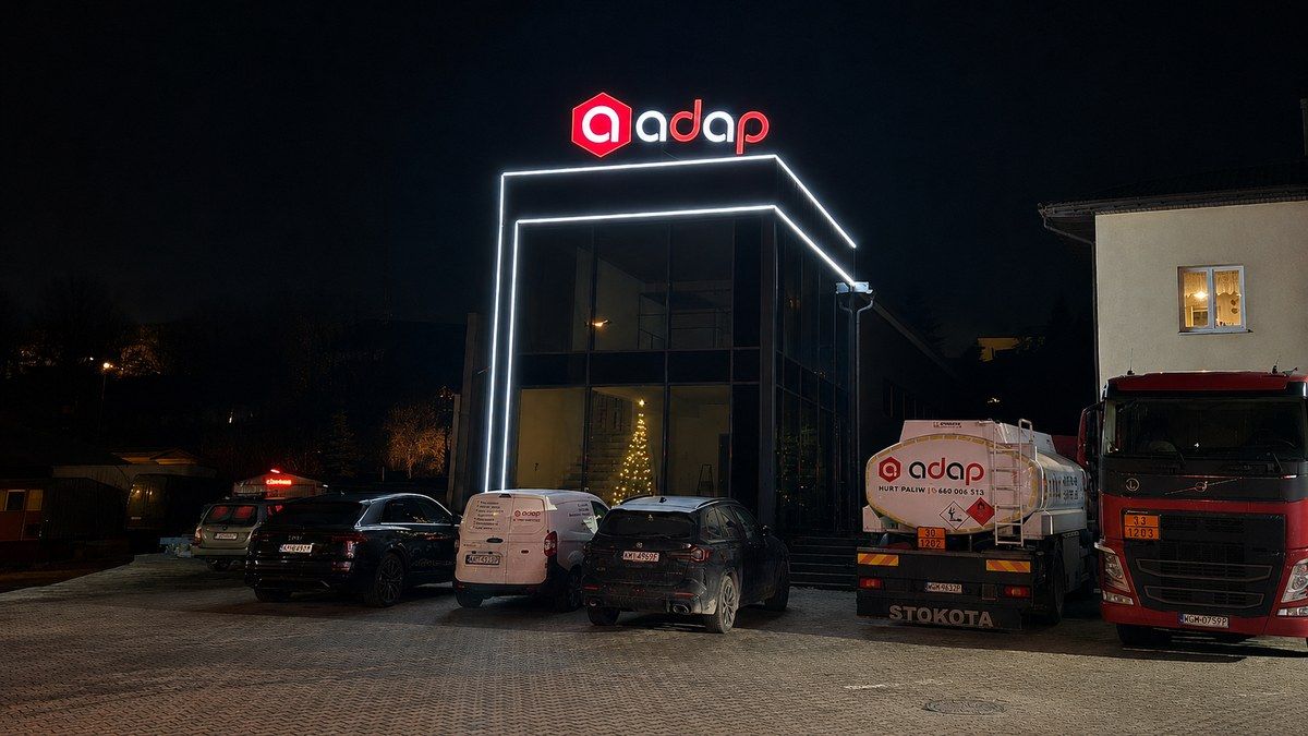 Stacja paliw ADAP nocą – przeszklona fasada aluminiowa, realizacja stolarki dla obiektu usługowego (Trendhomes)